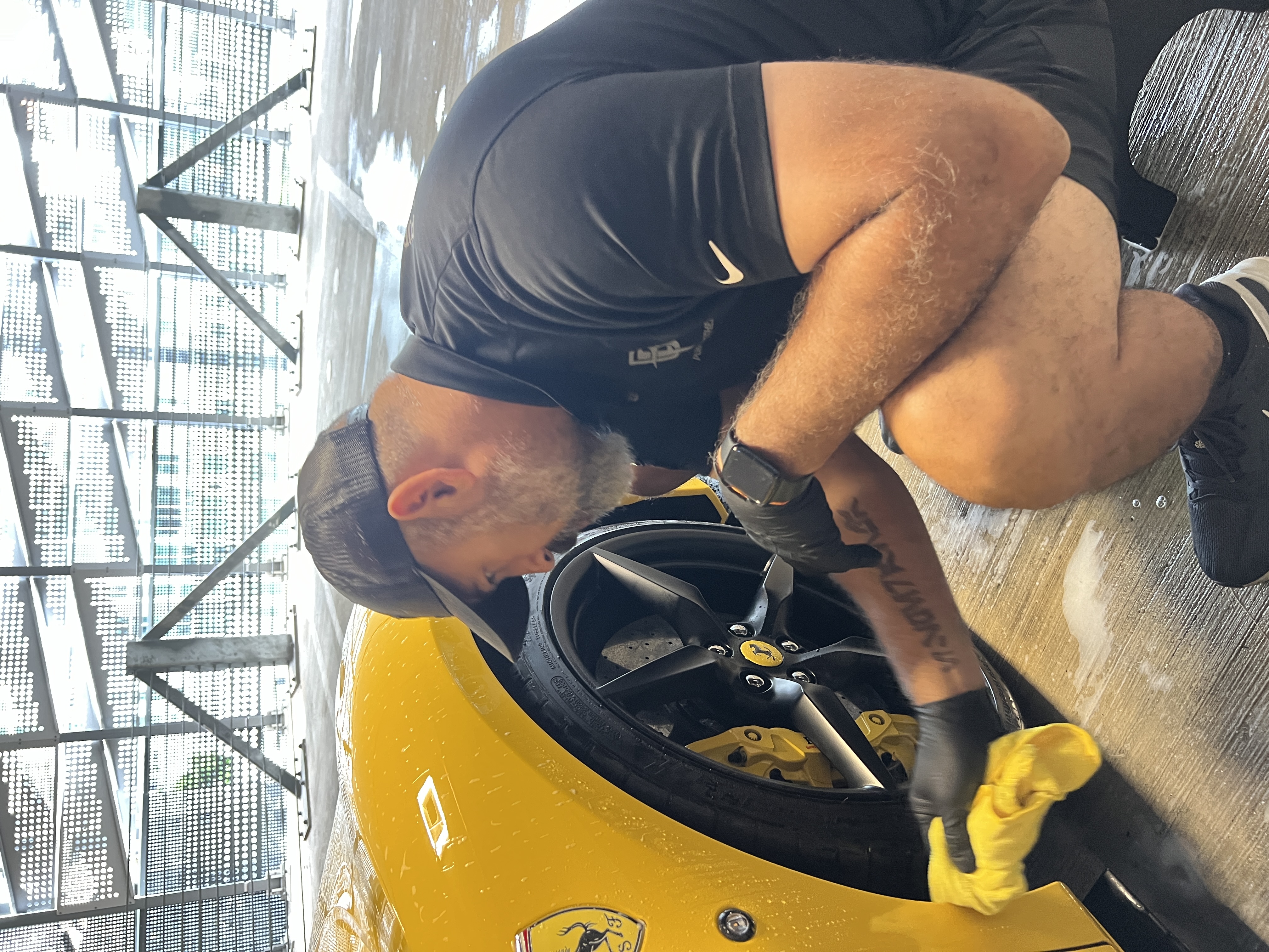 Angel Moreno detailing a yellow Ferrari wheel